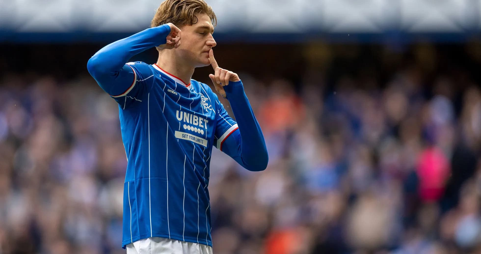 Player celebrating with a shushing gesture after scoring