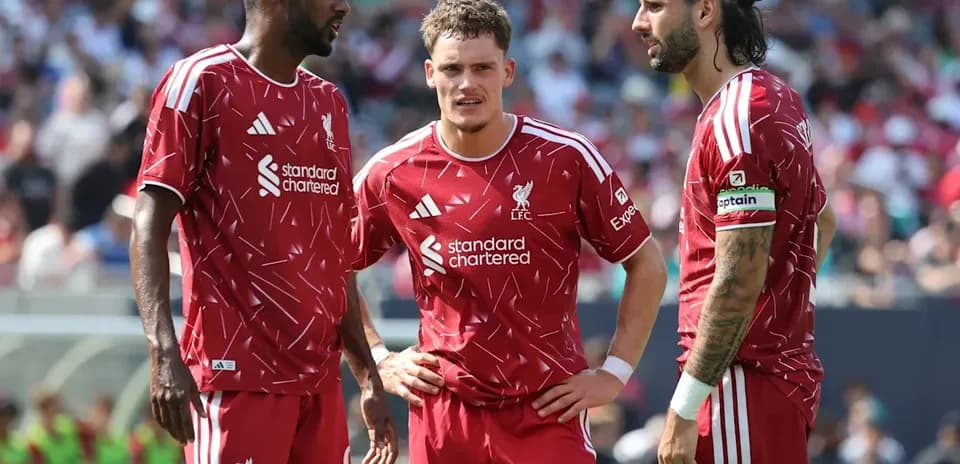 Three Liverpool players discussing during a match