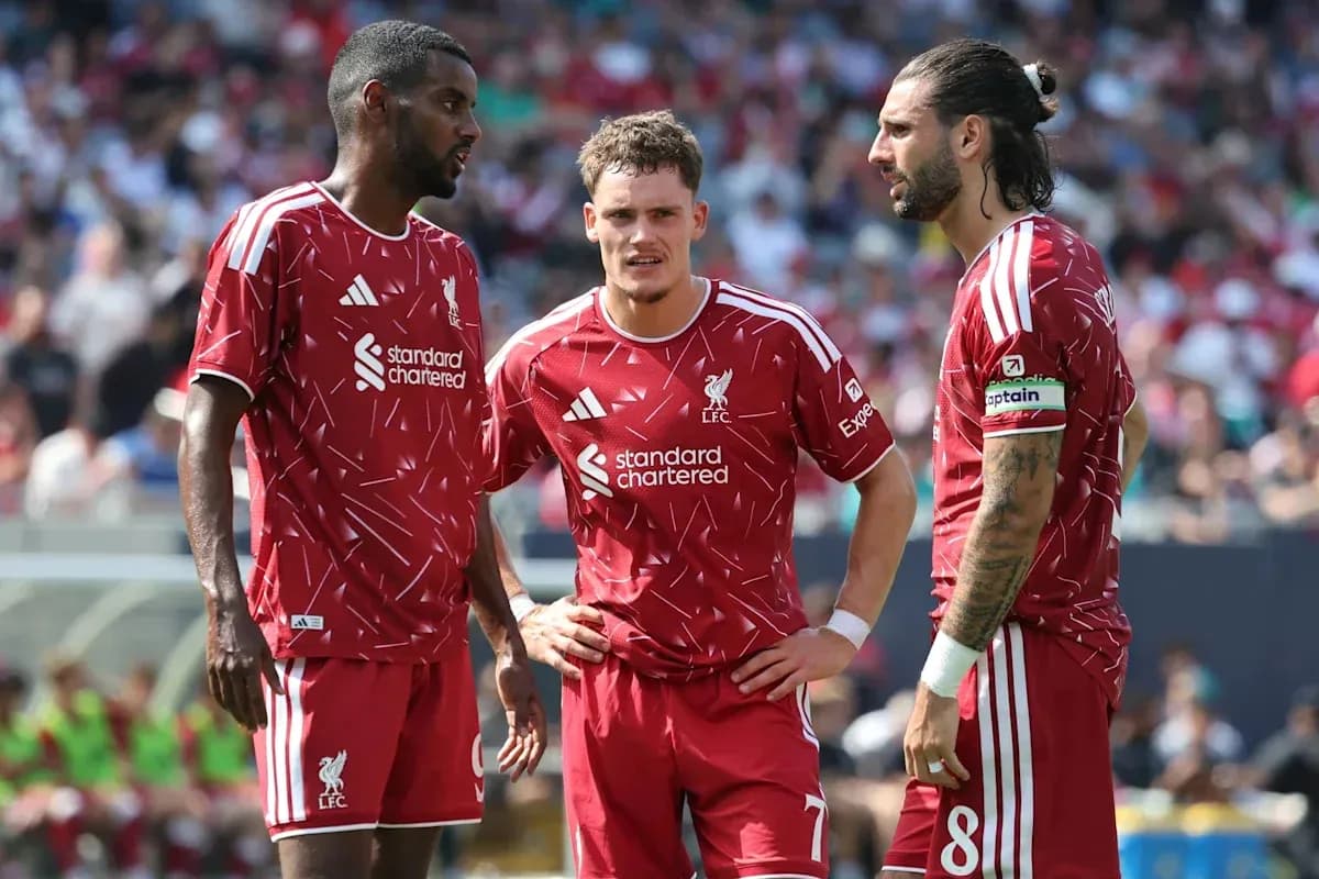 Three Liverpool players discussing during a match Three Liverpool players discussing during a match