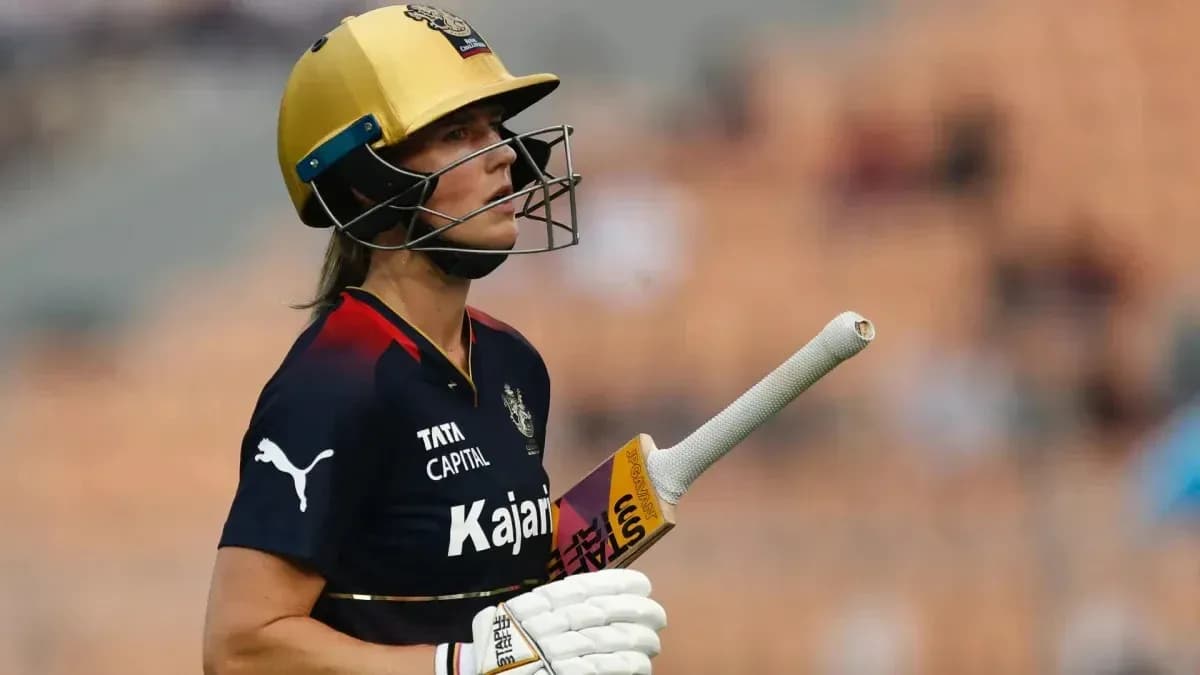 Cricketer walking off field with bat in hand