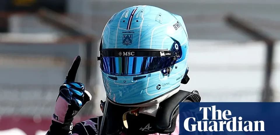Racing driver celebrating with helmet and raised finger