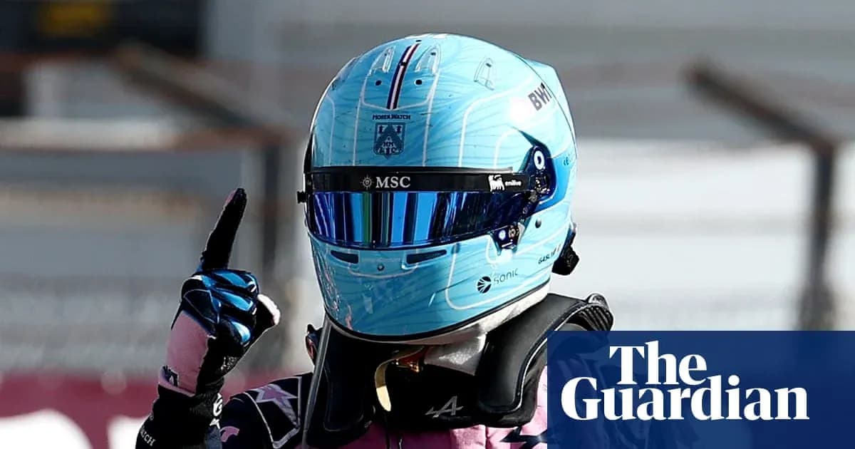 Racing driver celebrating with helmet and raised finger