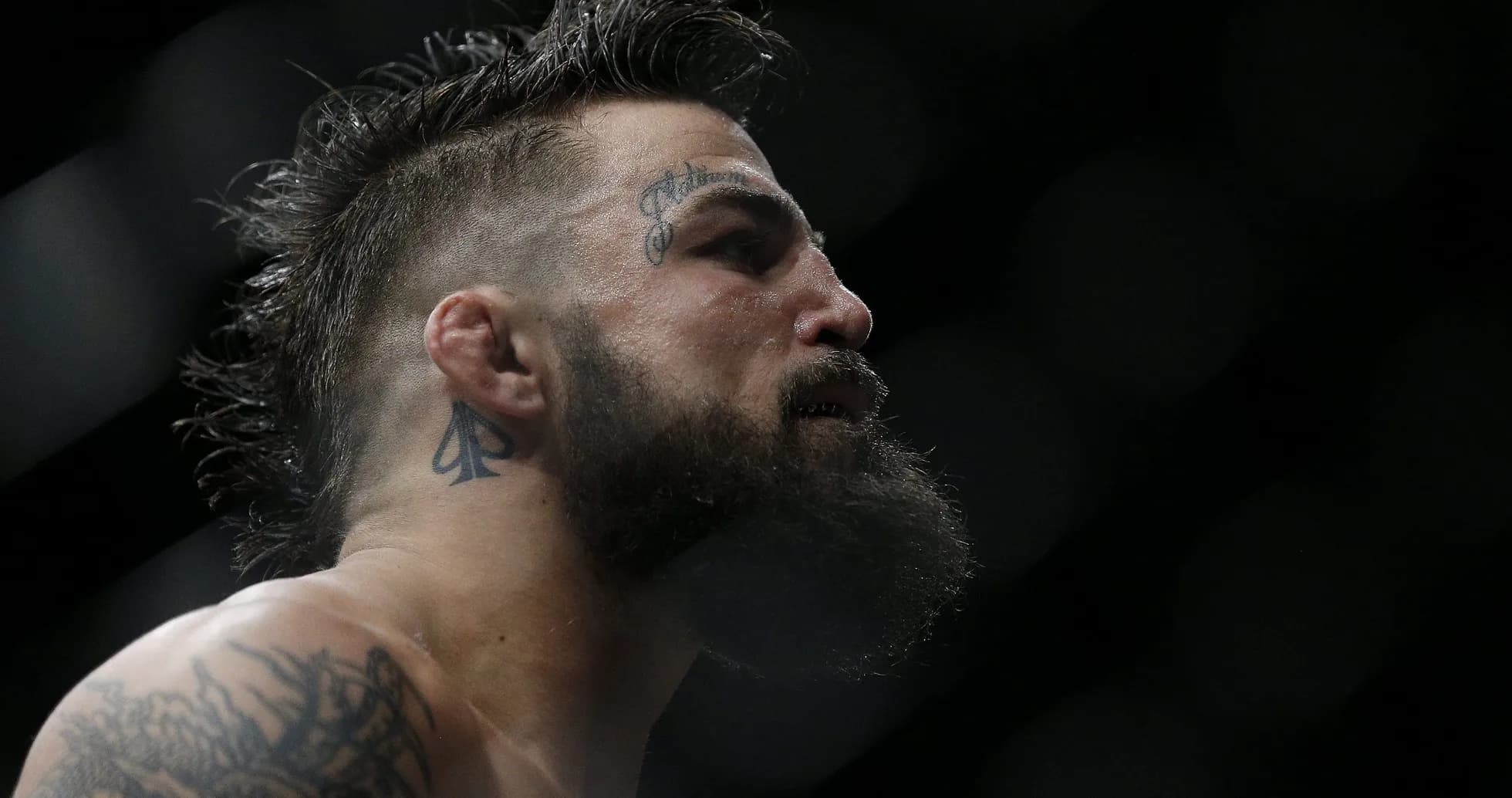 Profile view of fighter with tattoos and beard