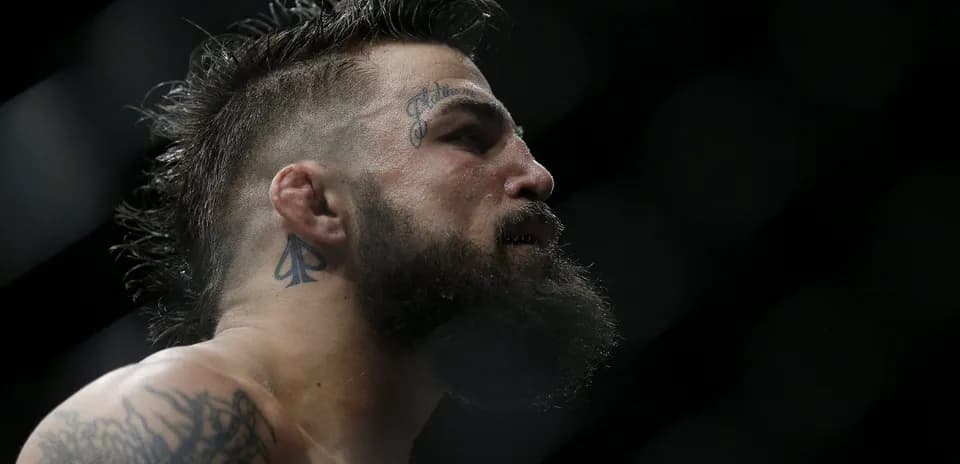 Profile view of fighter with tattoos and beard