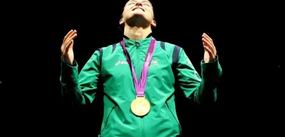 Athlete celebrating with gold medal on podium