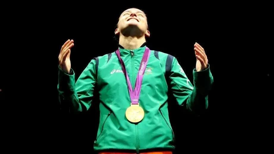 Athlete celebrating with gold medal on podium