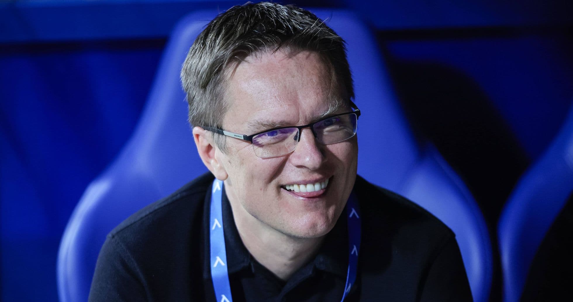 Man smiling while seated in sports venue