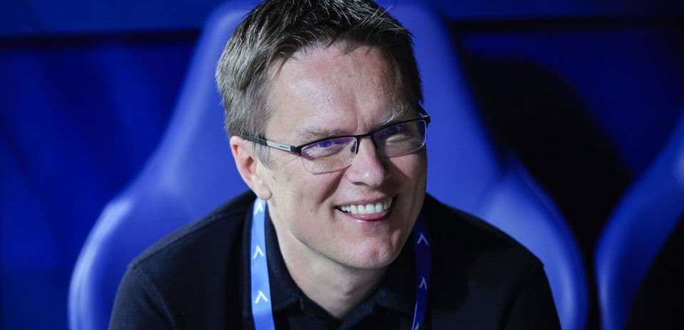 Man smiling while seated in sports venue