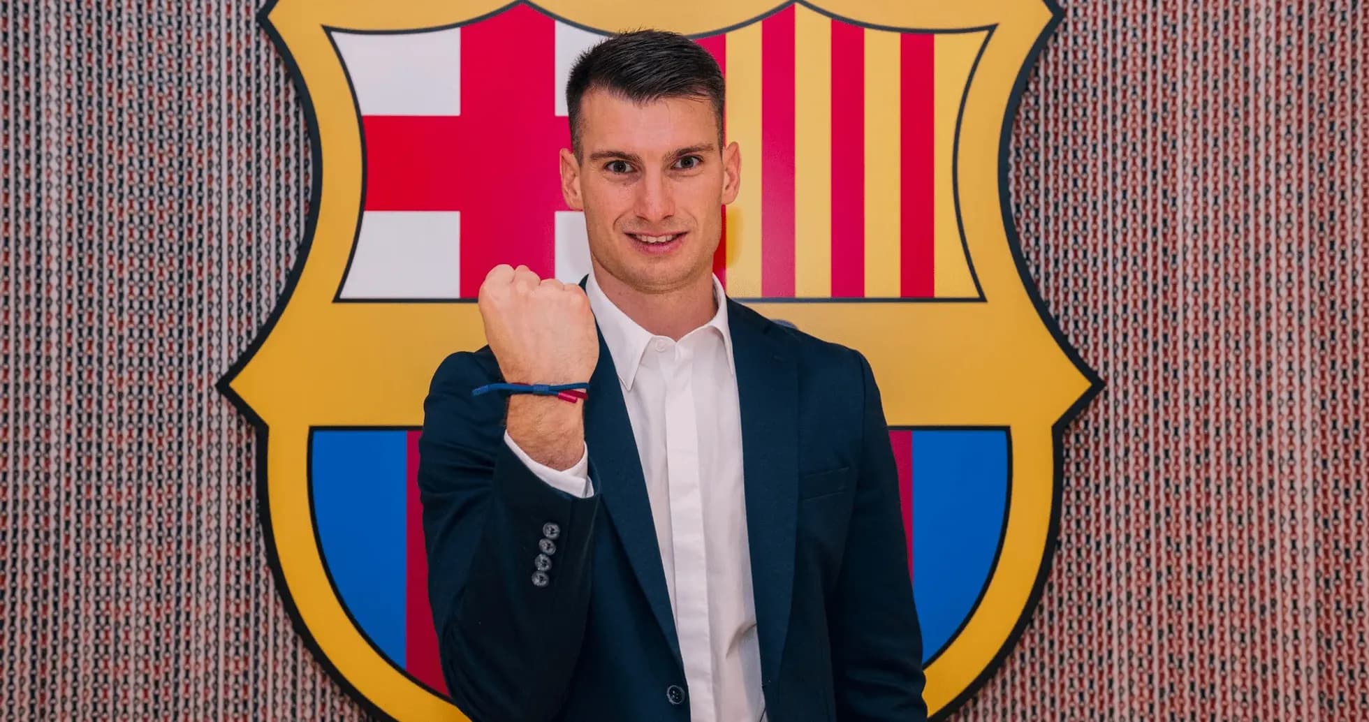 Player posing with Barcelona crest in background