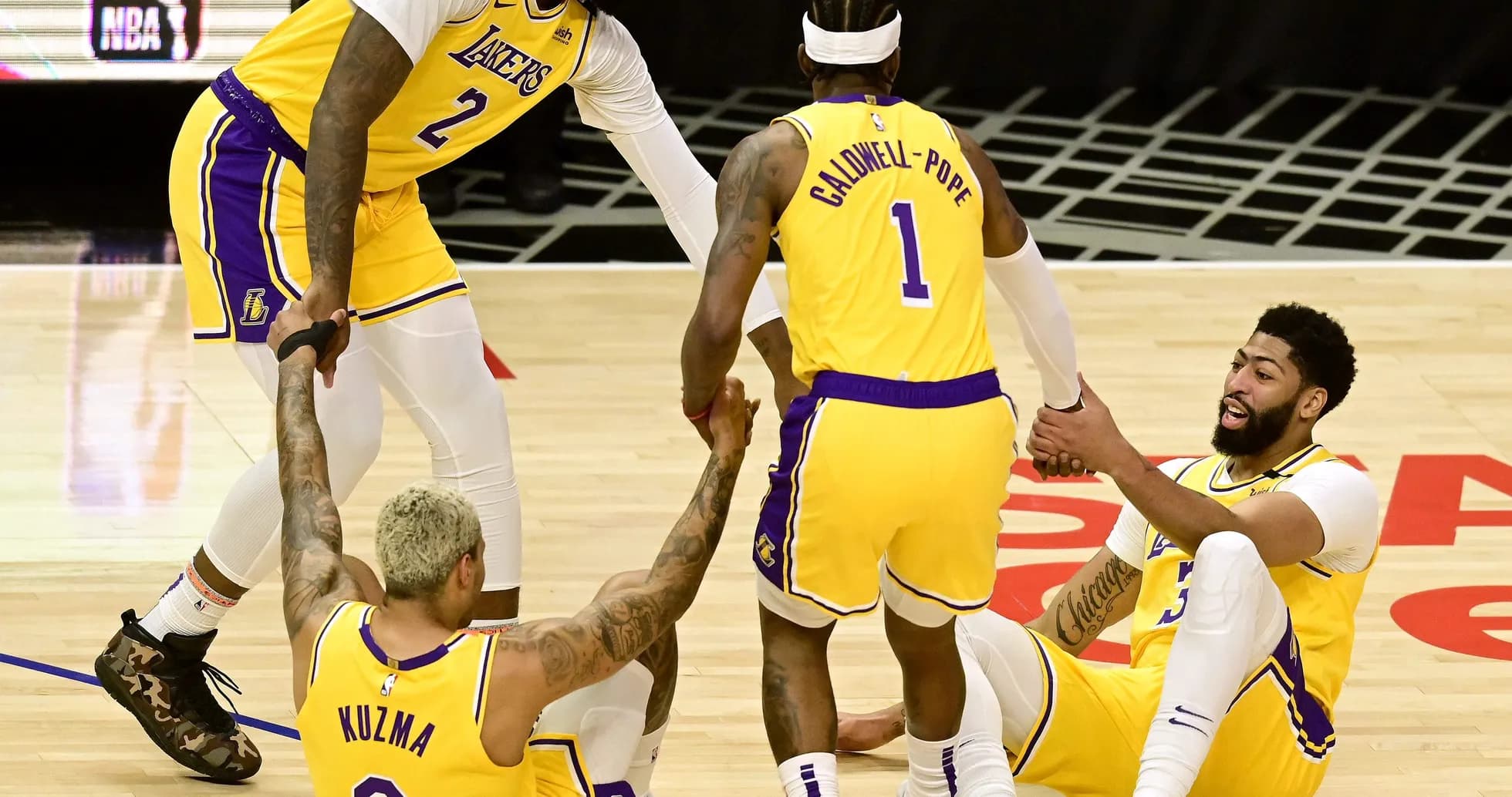 Los Angeles Lakers players assisting teammates on court