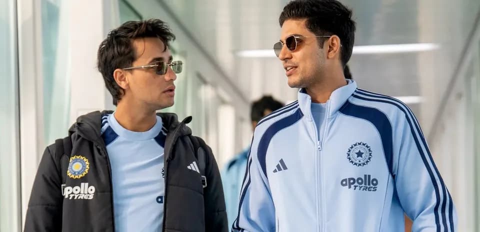 Two players walking in team tracksuits indoors