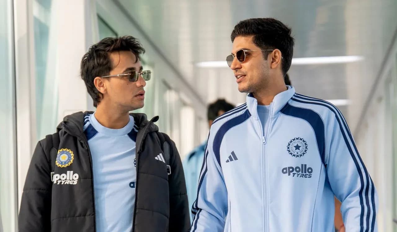 Two players walking in team tracksuits indoors