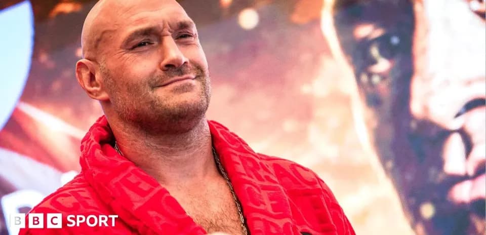 Boxer posing in red robe at promotional event