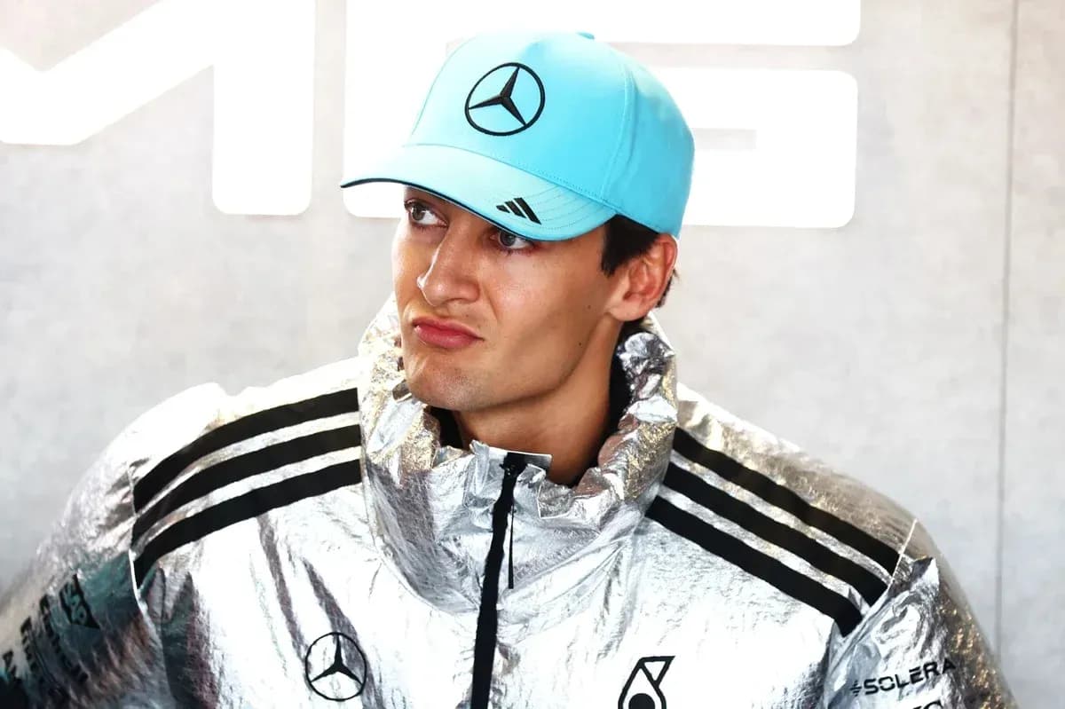 Driver in silver jacket and blue cap at event