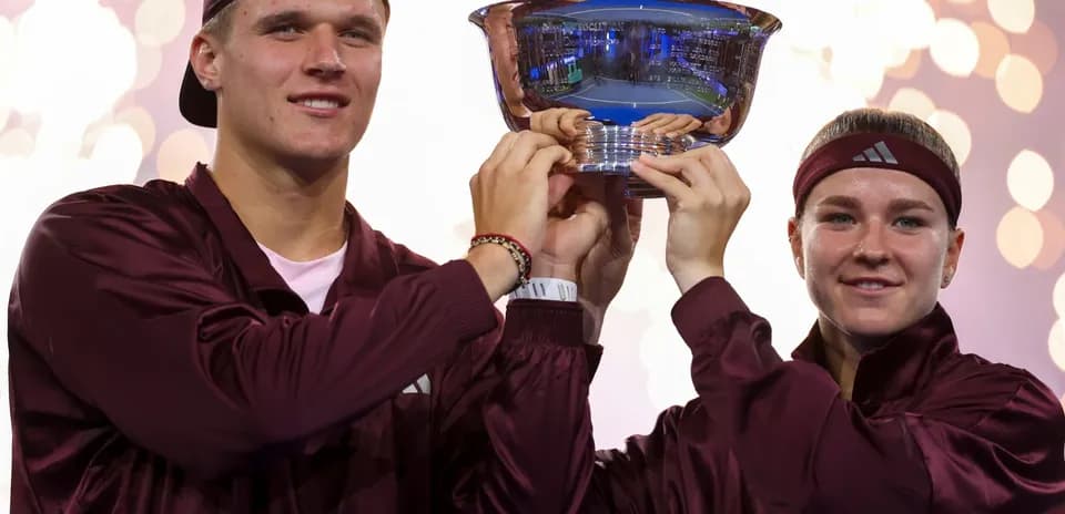 Players celebrating with trophy after tournament victory