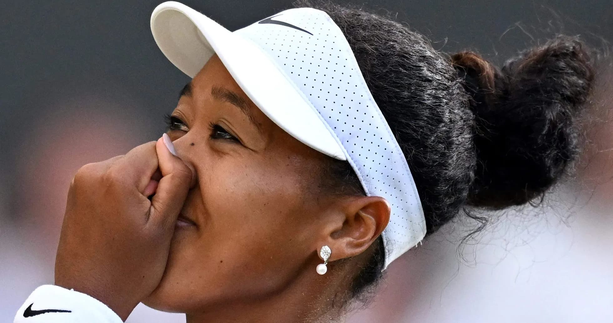 Naomi Osaka touching her face during a match