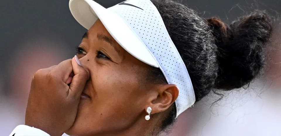 Naomi Osaka touching her face during a match