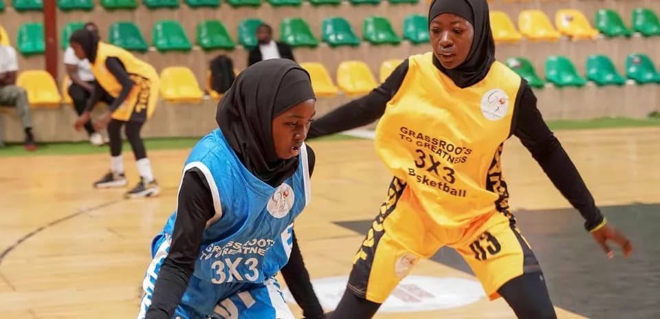 Two female players competing in a basketball match