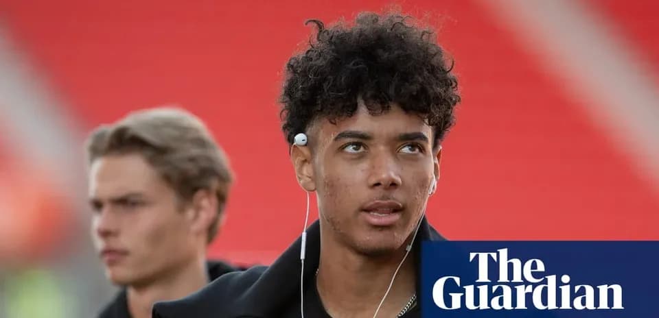 Two young men walking, one wearing headphones