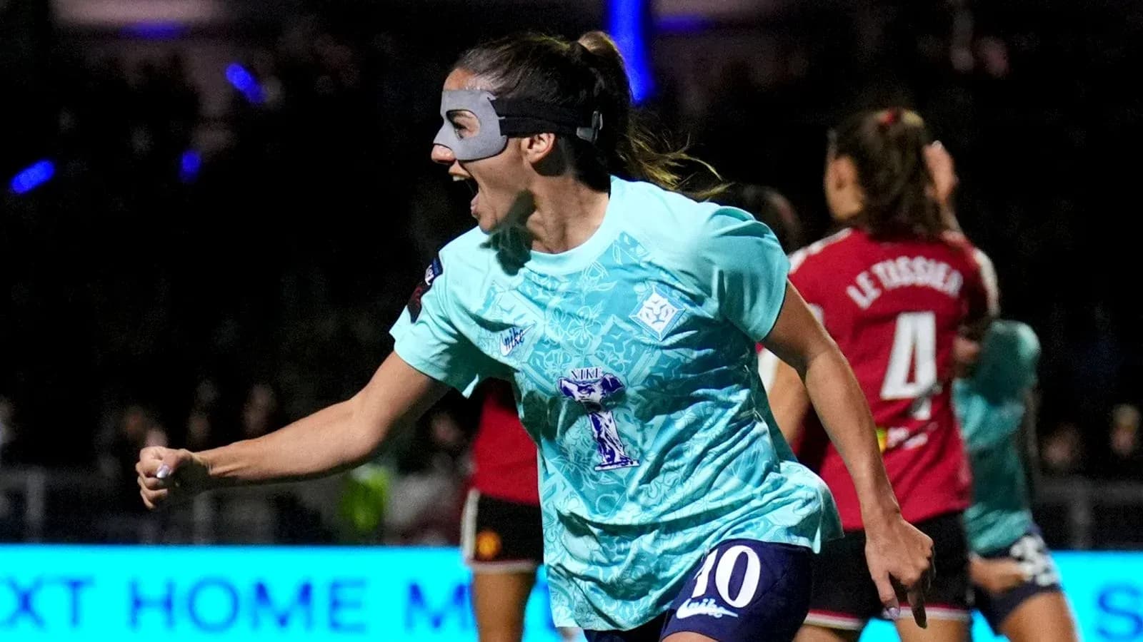 Player celebrating a goal wearing a protective mask