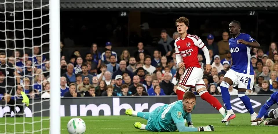 Arsenal player celebrates scoring against goalkeeper in match