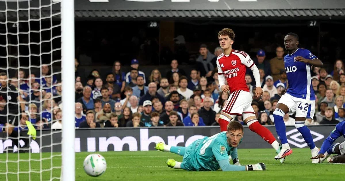Arsenal player celebrates scoring against goalkeeper in match