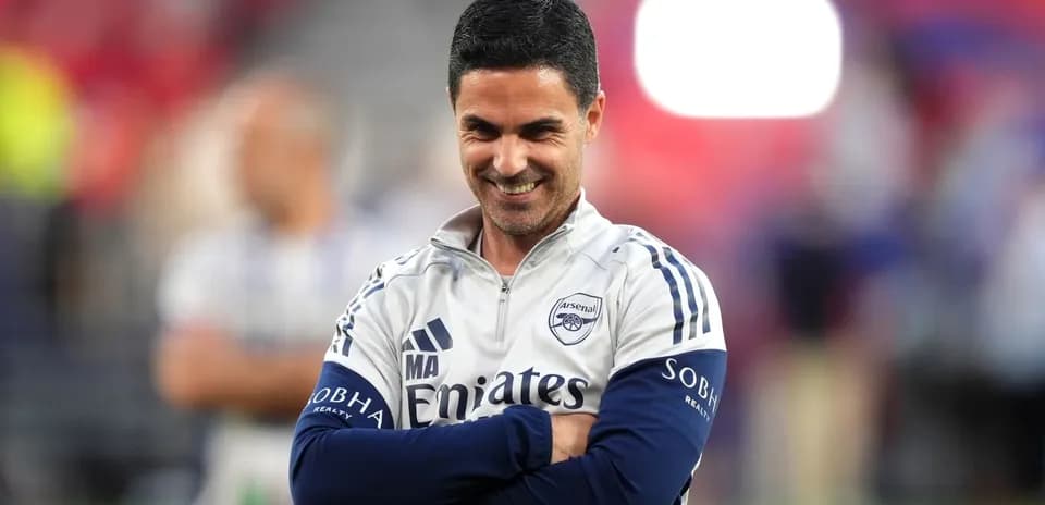 Arsenal manager smiling during warm-up session