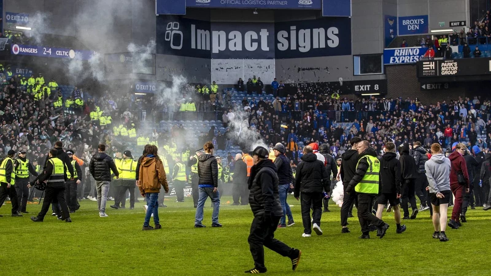 Crowd on pitch with smoke after football match