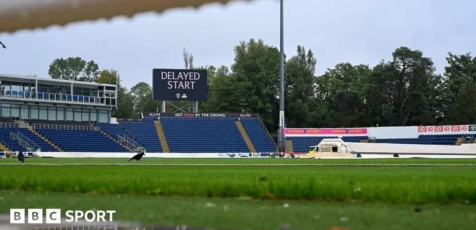 Cricket ground with delayed start sign and wet pitch