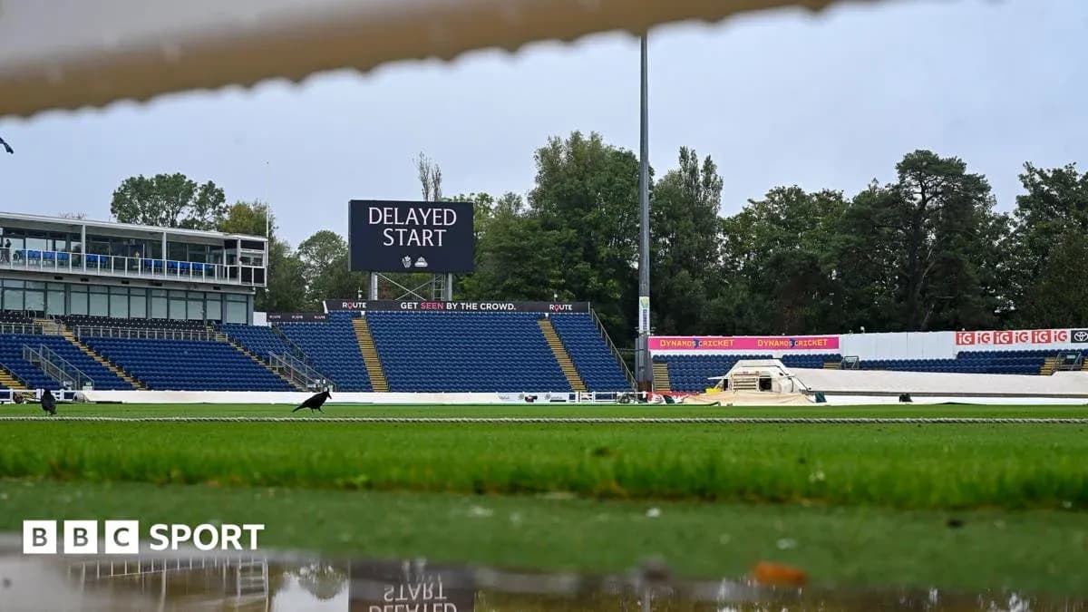 Cricket ground with delayed start sign and wet pitch