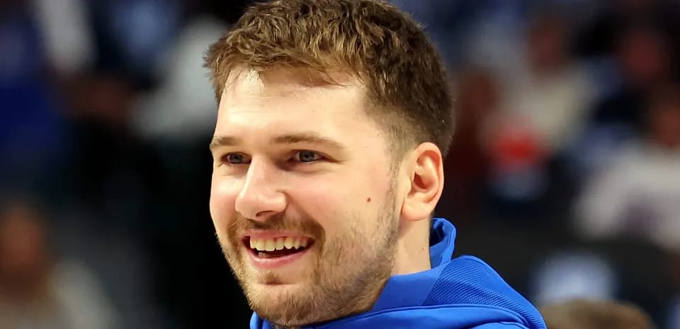 Player smiling while wearing blue warm-up jacket