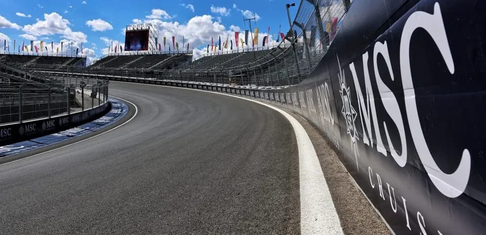 Curved racetrack with grandstands and advertising banners