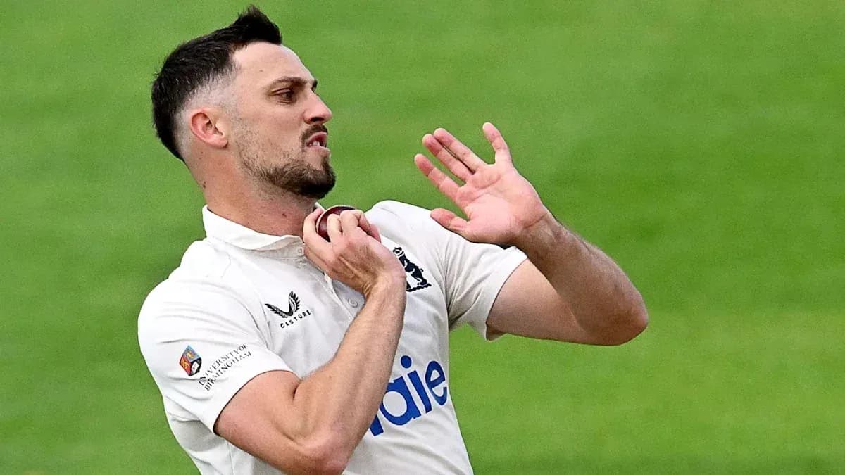 Cricketer adjusting collar during match play