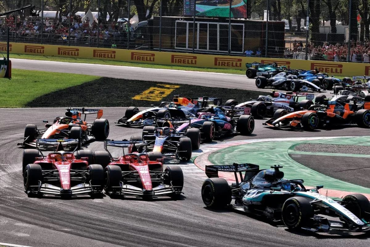 Multiple Formula 1 cars racing around a corner