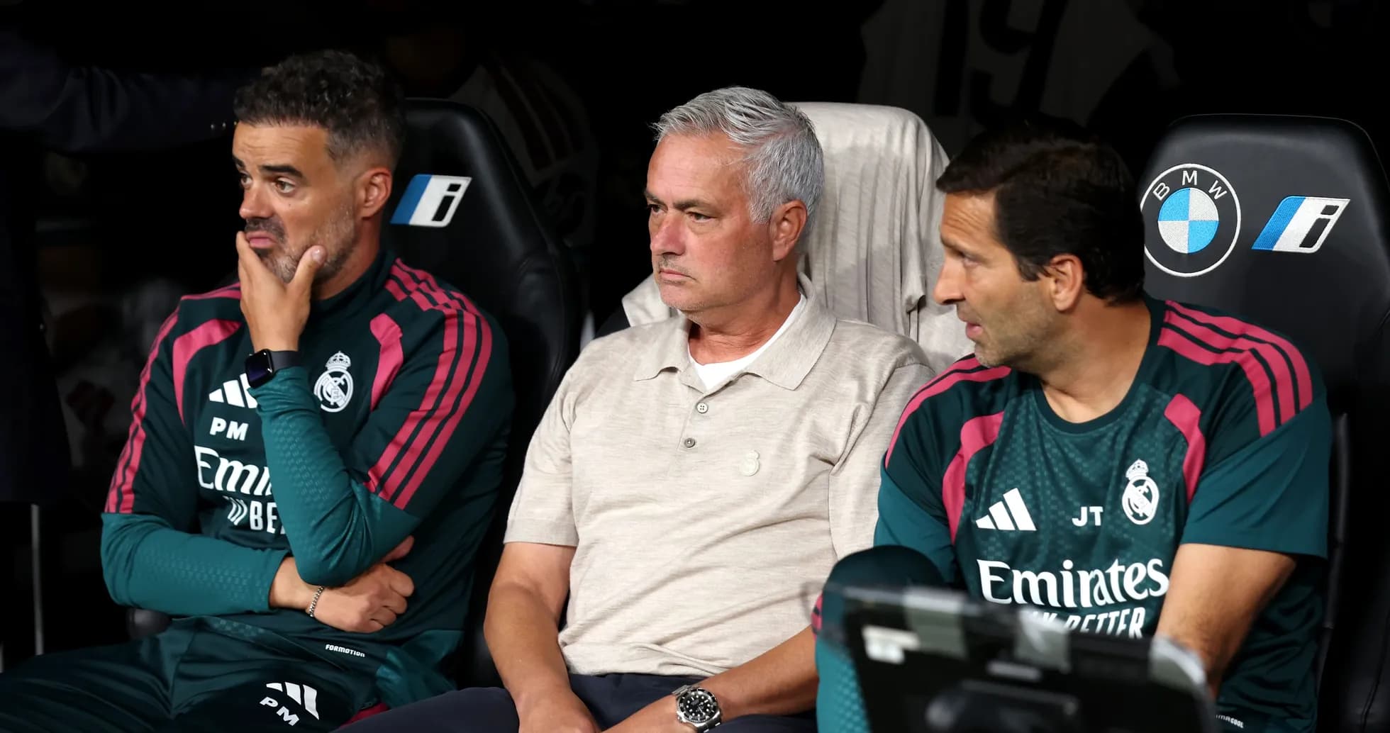 Coaching staff seated on bench during match