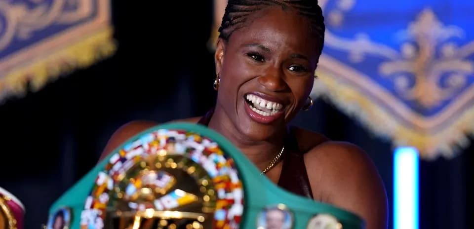 Boxer smiling while holding championship belt