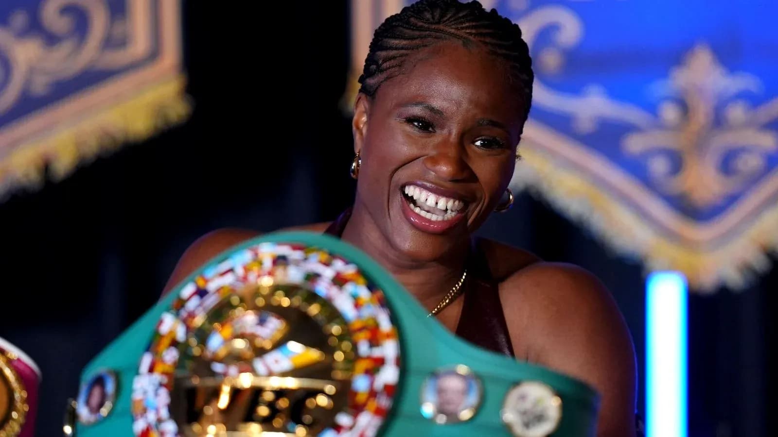 Boxer smiling while holding championship belt