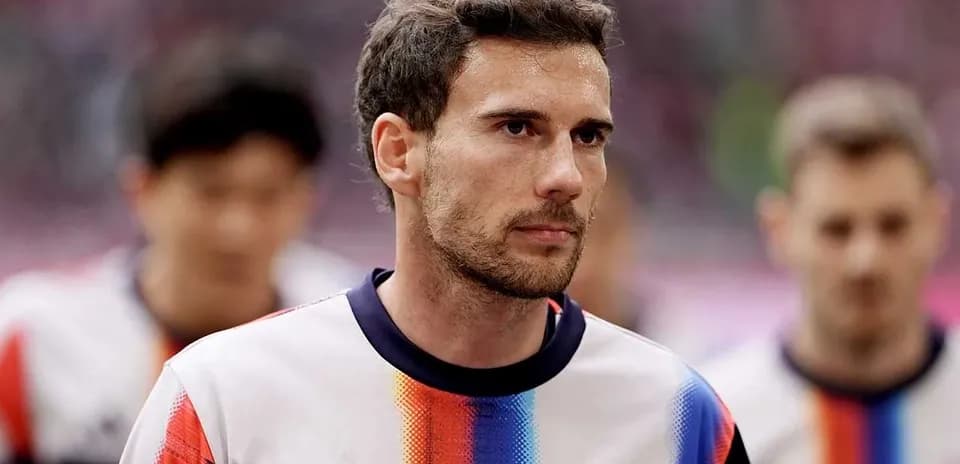 Player walking onto the pitch in team jersey