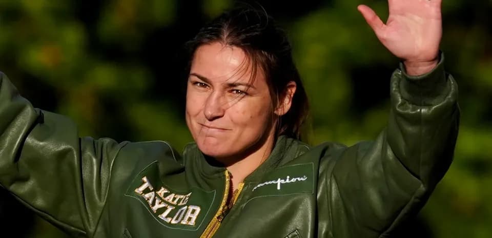 Katie Taylor waving while wearing a green jacket