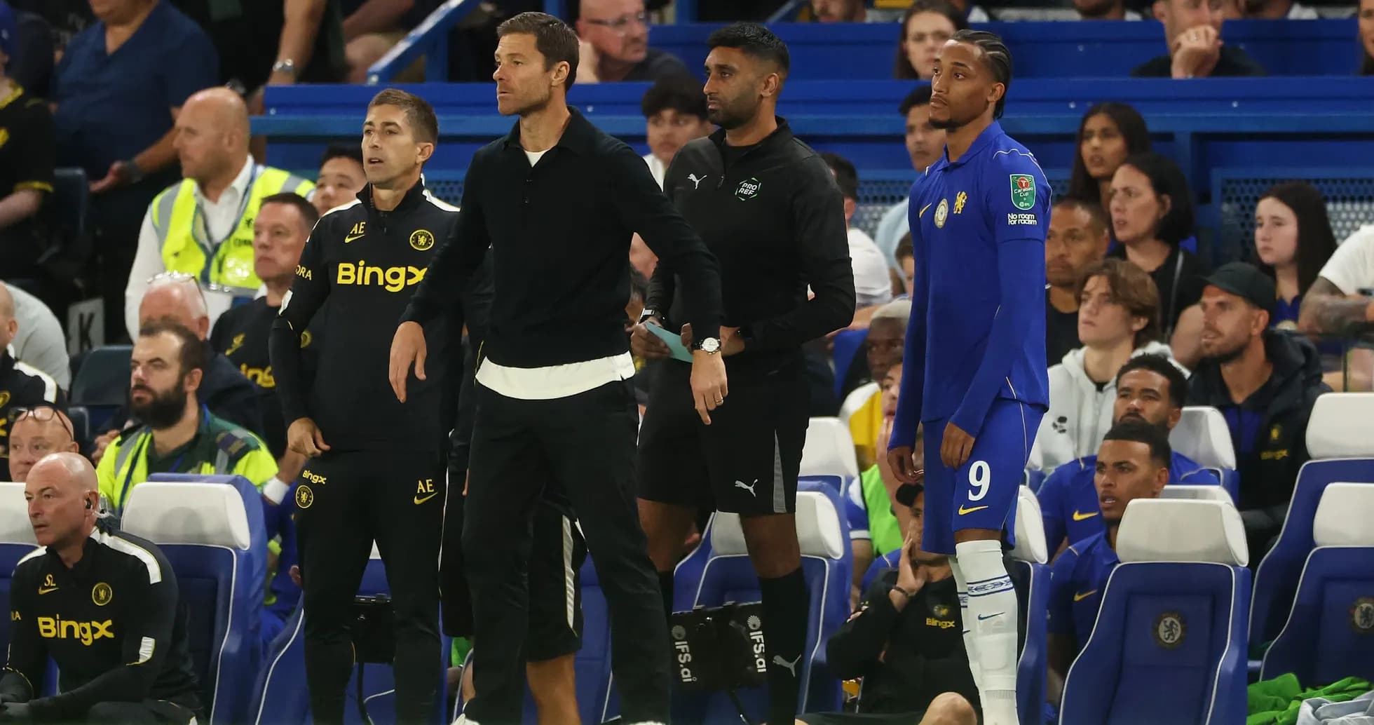 Coaches and players on the sidelines during match