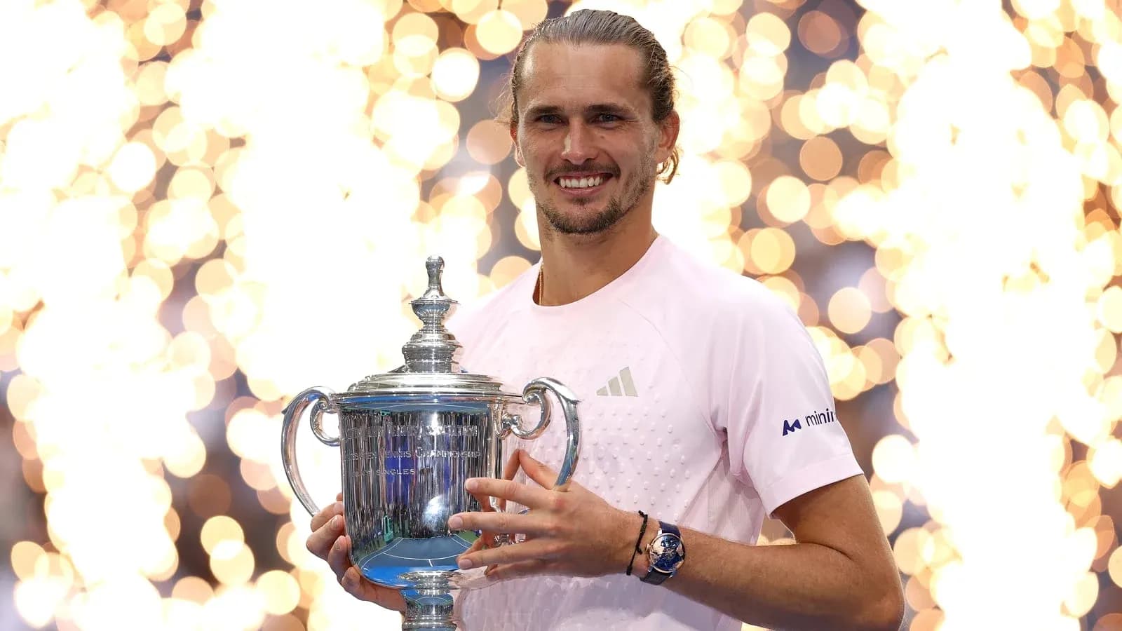 Player holding trophy with celebratory lights in background