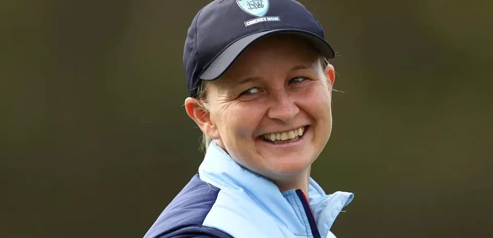 Cricket coach smiling during outdoor session