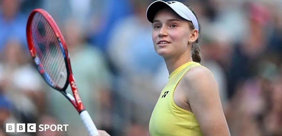 Tennis player smiling while holding racket on court