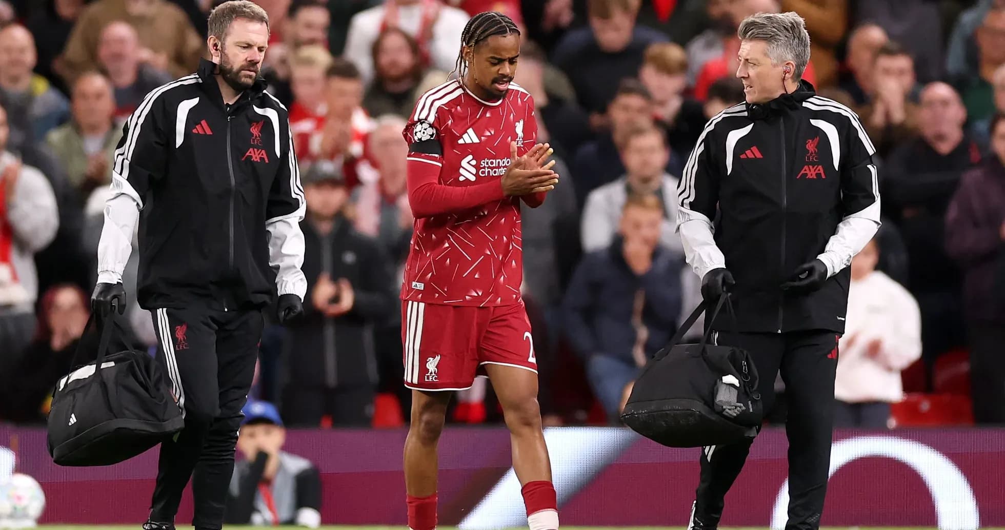 Liverpool player being assisted off the field