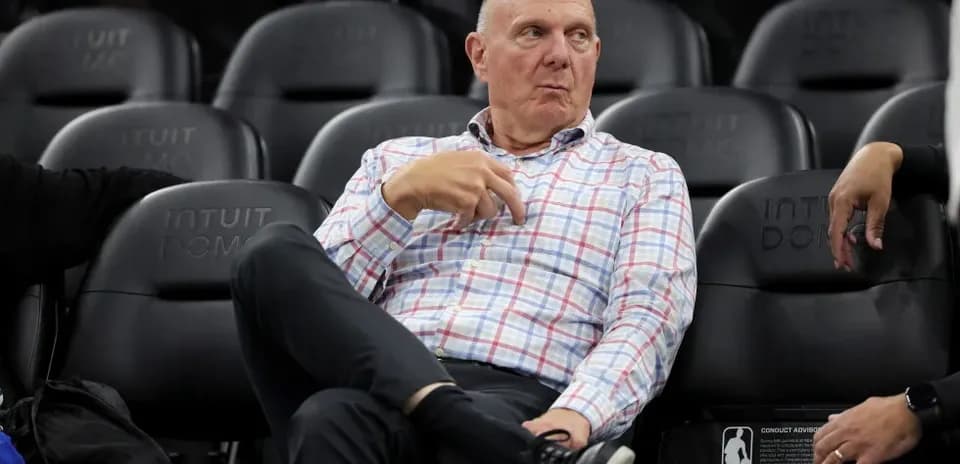Man seated in arena, observing the game