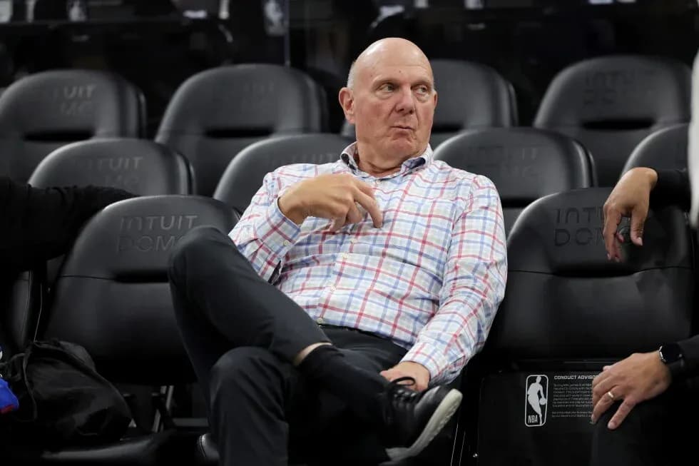 Man seated in arena, observing the game