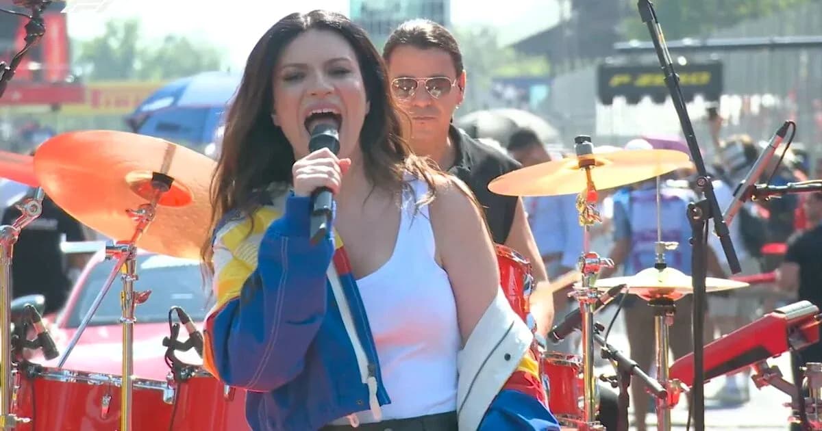 Singer performing with band at outdoor concert