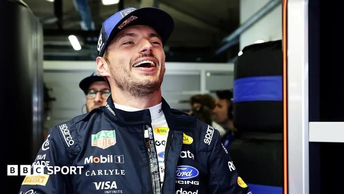 Driver smiling in team garage before race