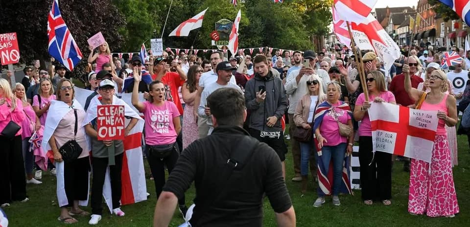 Large crowd protesting with signs and flags