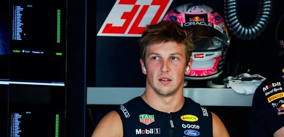Driver in garage with racing gear and helmet